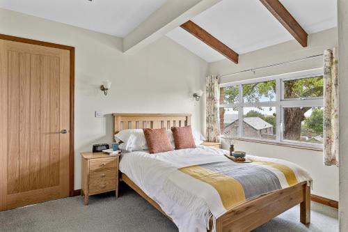 a bedroom with a large bed and a window at Fuchsia Cottage in Saint Endellion