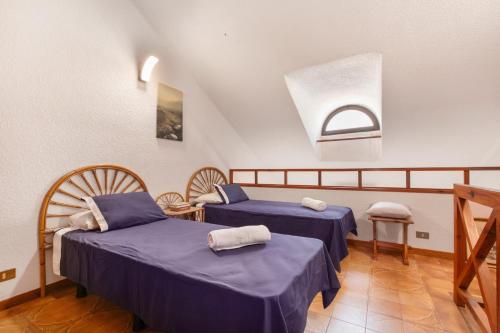 a room with two beds and a window at La Casita de Arise in Playa de las Americas