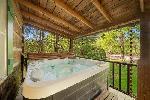 a jacuzzi tub on the deck of a house at Bridgepoint Cabin in Banner Elk