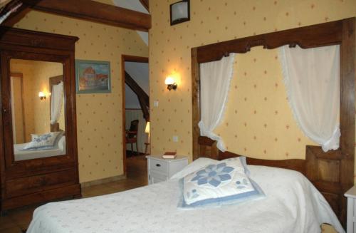 Un dormitorio con una cama con una colcha blanca. en Gîte Nautilus, en Elven