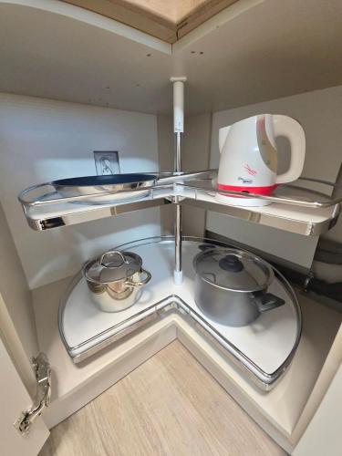 a kitchen with two shelves with pots and pans at Emma's Appartment with Free Parking in Nivy