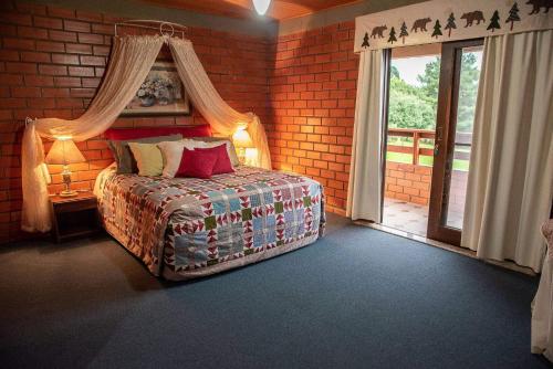 a bedroom with a bed and a large window at A Cabanha in Caçador