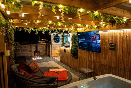 a room with a bath tub and a television and lights at Tan Y Bryn Glamping in Conwy
