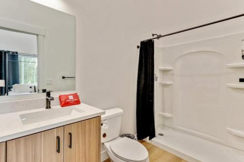 a bathroom with a toilet and a sink and a mirror at 3 Min to DT - 2 Car Garage - Lux Townhome - King Bed in Salt Lake City