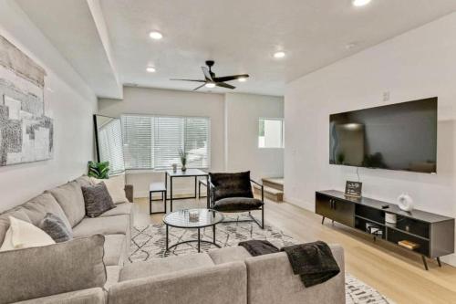 a living room with a couch and a flat screen tv at 3 Min to DT - 2 Car Garage - Lux Townhome - King Bed in Salt Lake City