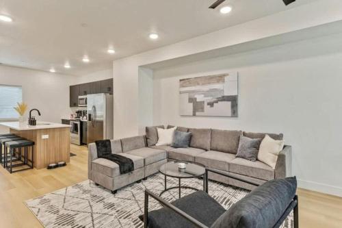 a living room with a couch and a kitchen at 3 Min to DT - 2 Car Garage - Lux Townhome - King Bed in Salt Lake City