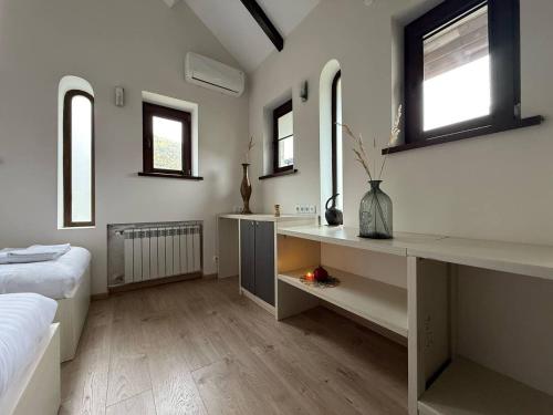 Un dormitorio con una cama y un escritorio y dos ventanas. en Irbis hotel, en Mestia