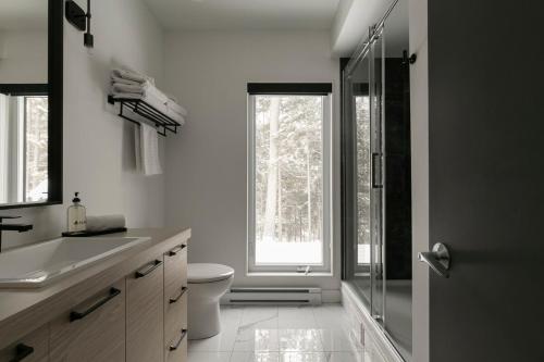 a bathroom with a toilet and a glass shower at Scenic Bright - Sauna - Fire - 20 min Tremblant in La Conception