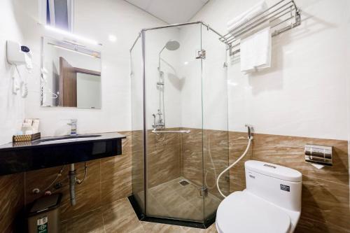Un baño con ducha de cristal y un inodoro. en Wisteria Hotel Dalat, en Da Lat