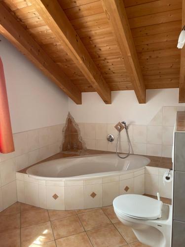 a bathroom with a tub and a toilet in it at Ferienhaus Eugler in Weitnau