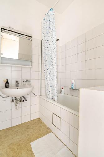 a white bathroom with a sink and a bath tub at Historic Gem - Lift - Balcony in Basel