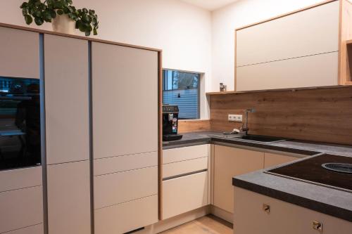 KranglFerienwohnung Kratzwald的带白色橱柜和水槽的厨房