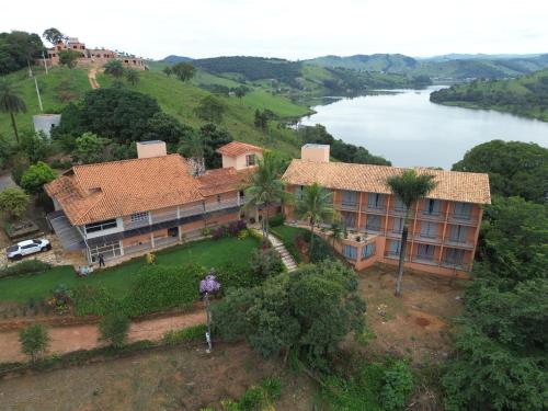 une vue aérienne d'une maison avec un lac dans l'établissement Recanto Inaciano Saúde e Paz, à Capitólio