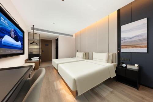 a bedroom with two beds and a flat screen tv at Atour Hotel Shanghai Dapu Bridge ASE Center in Shanghai