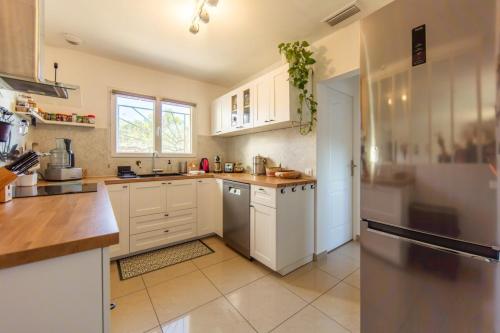 een keuken met witte kasten en een koelkast bij Villa Goya in Ares with private pool in Arès