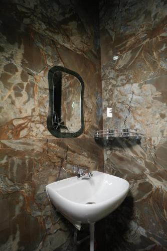 a stone bathroom with a sink and a mirror at Om Palace Inn in Varanasi