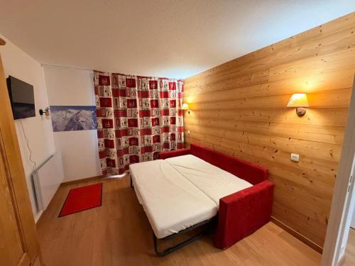 a small room with a bed in a wooden wall at Résidence Les Lumières des Neiges et parking in Valmeinier