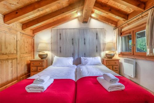 a bedroom with a large red bed with towels on it at Amethyste - 2 Bedrooms & Free Parking - By Cozee Rentals in Les Houches