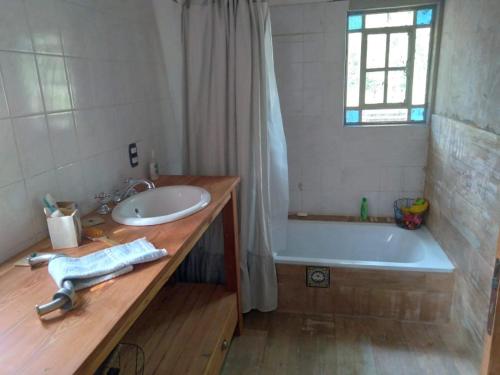 ein Badezimmer mit Waschbecken und Badewanne in der Unterkunft Munay in Villa Gesell