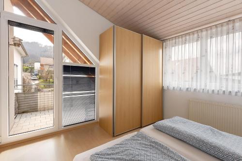 a bedroom with a bed and a large window at Obstbau Koch in Bodman-Ludwigshafen