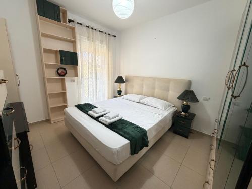 a bedroom with a bed with two towels on it at Riva'S Apartament in Shkodër