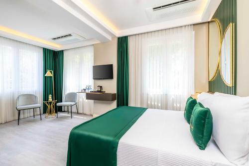 a bedroom with a green and white bed and a desk at Sistina Old City Hotel in Istanbul
