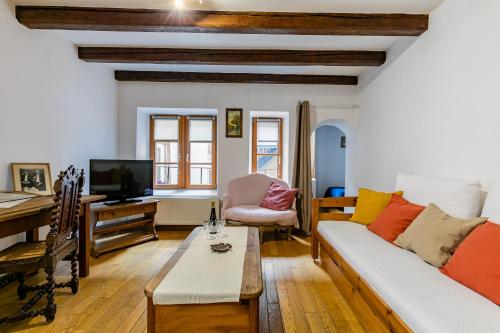 un salon avec un canapé et une table dans l'établissement Charmant et typique 2 pièces Place de la Cathédrale, à Strasbourg