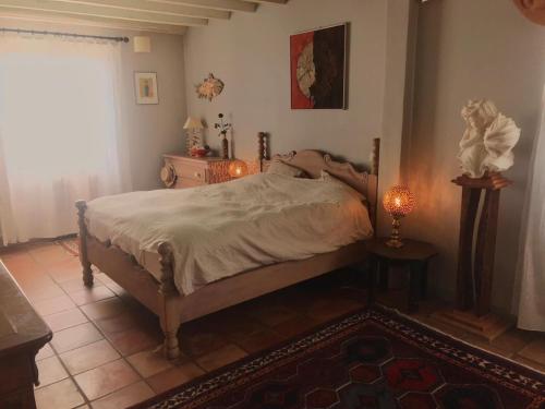 a bedroom with a bed and a table and a window at Vieille House in Saint-Geours-de-Maremne