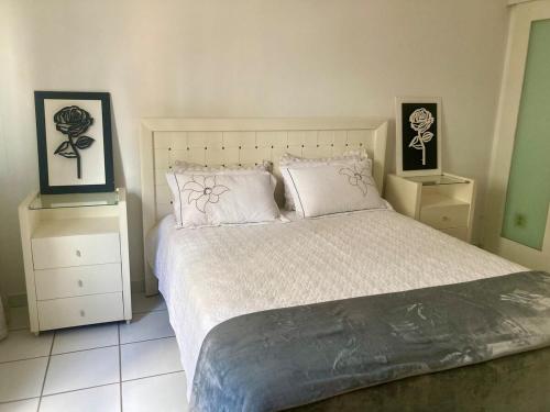 a bedroom with a large bed with two night stands at Conforto e espaço - 3 quartos, 3 vagas e a 150m do mar in Guarapari