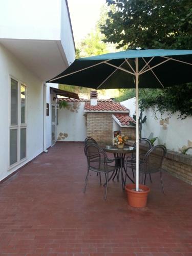 a patio with a table and chairs with an umbrella at La Noce Bed and Breakfast in Chieti