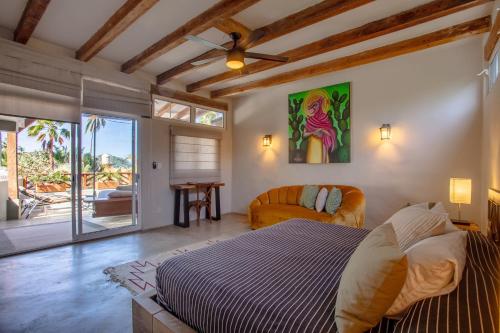 un dormitorio con una cama y un sofá en Casas Palmar and Tocayo, en Sayulita