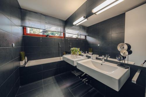 プラハにあるDesign Architect Villa with 2 Apartmentsの洗面台が2つと鏡が2つあるバスルーム