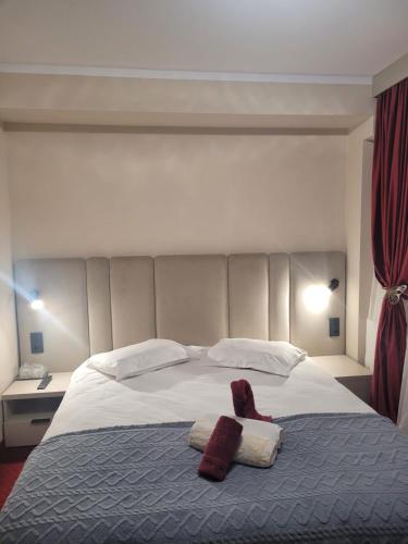 a bedroom with a large bed with two towels on it at Pensiunea ELEMAR in Azuga