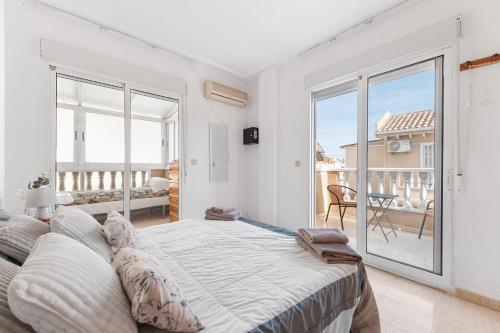 a bedroom with a large bed and a balcony at Casa de Espãna in Torrevieja