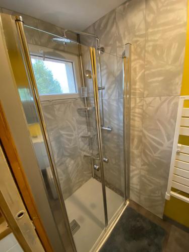 una doccia con una porta in vetro in un bagno di studio classé à sommières a Sommières
