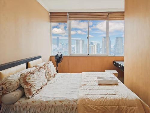 a bedroom with a bed and a large window at Newly Large 2BR Ambassador2 Apt with Pool Gym WiFi in Jakarta