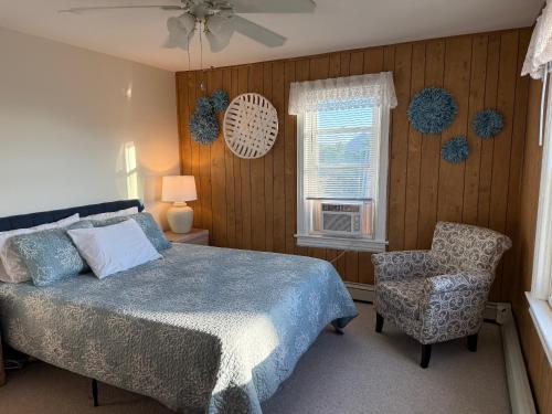 ein Schlafzimmer mit einem Bett und einem Stuhl und einem Fenster in der Unterkunft 3 Bedroom 2 bath Beach House condo- 10 houses from the beach walk to the beach in Seaside Park