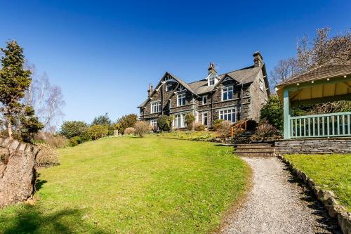 a large house on top of a grassy hill at The Lakehouse Rooms at The Waterhead Inn, Ambleside in Ambleside
