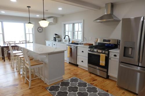 a kitchen with white appliances and a table with chairs at Tranquility Near Hudson & The Berkshires in Chatham