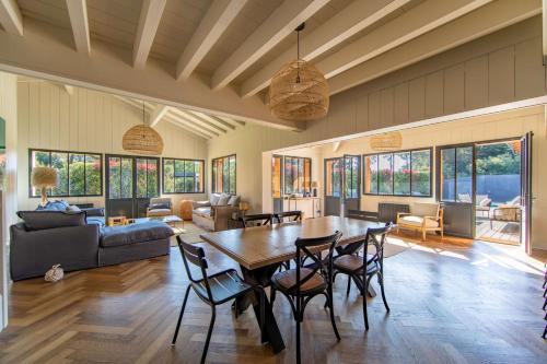 a large living room with a table and chairs at Villa Palombes au Cap Ferret charming villa with swimming pool in Cap-Ferret