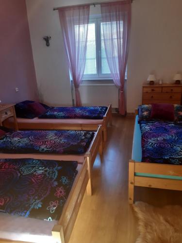 a room with three beds and a window at U paní malířky in Valtice