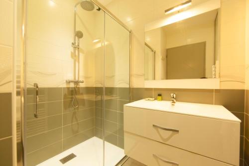 a bathroom with a glass shower and a sink at Appartement Villa De L'Arche en plein centre-ville in Andernos-les-Bains