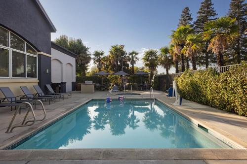 - une piscine dans une cour avec des chaises et des arbres dans l'établissement Fairfield Inn Sacramento Cal Expo, à Sacramento