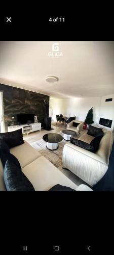 a large living room with couches and tables at Villa Ola in Gjilan