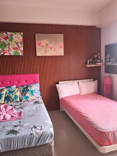 a bedroom with two beds and a red striped wall at Lelani's Comfy Condo in Mactan