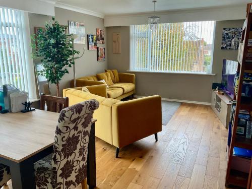 サウスポートにあるSouthport-Birkdale Luxury Havenの黄色いソファとテーブルのあるリビングルーム