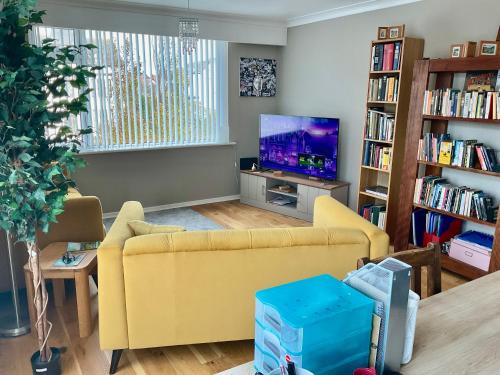 サウスポートにあるSouthport-Birkdale Luxury Havenのリビングルーム(黄色のソファ、テレビ付)