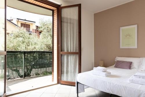Un dormitorio con una cama y una puerta corrediza de vidrio. en De Homes - Appartamento con Terrazza vicino Assago e Milano, en Buccinasco