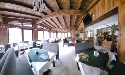 una grande stanza con divani, tavoli e finestre di Pensiunea ELEMAR ad Azuga