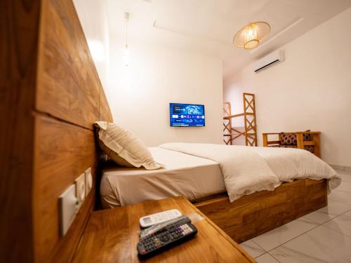 Natu Resort的一间卧室,配有一张床和一张桌子上的遥控器